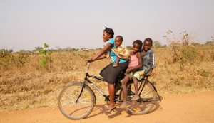 A woman carrying children on a bicycle